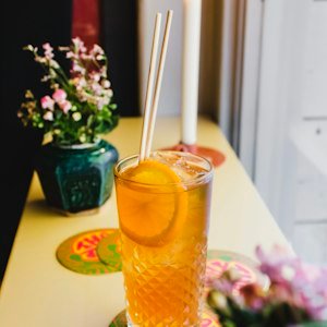 Iced orange drink with a straw and citrus slice on a sunny windowsill, Dutch Bros Mistletoe Rebel guide